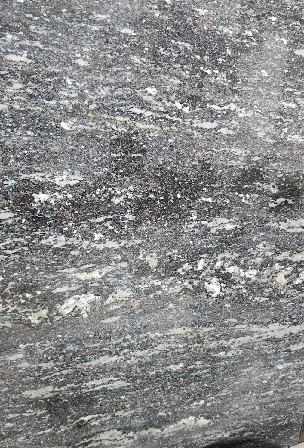 Polished slab of Paradiso granite in grey tones