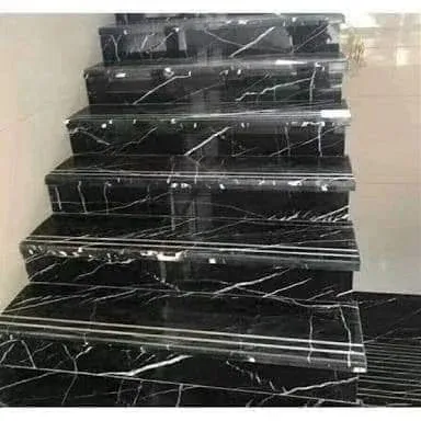 Close-up of black marble stair treads with white veining and grooved nosing
